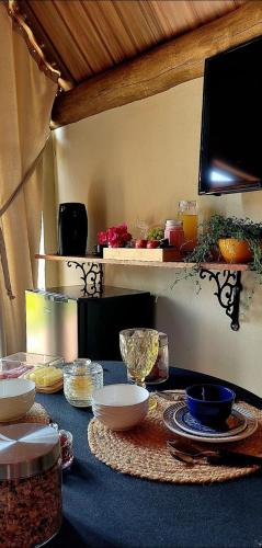 a table with bowls and plates on top of it at Pousada Chácara Kioski in Brotas