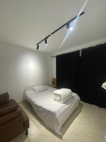 1 dormitorio con cama blanca y cortina negra en Butterfly, en Madinaty