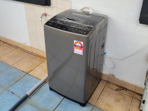 a trash can sitting on the floor next to a wall at Homestay Melor Serendah in Serendah
