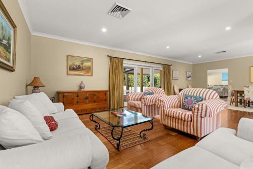 a living room with a white couch and chairs at Bella Casa by Latitude South Coast in Berry