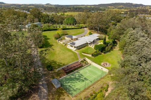 an aerial view of a house with a tennis court at Bella Casa by Latitude South Coast in Berry