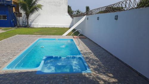 a small swimming pool next to a white fence at Chalés Lemes in Anchieta