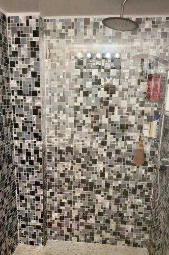 La salle de bains est pourvue d'une douche et de mosaïques. dans l'établissement Emplacement exceptionnel pour 4 personnes, à Boulouris-sur-Mer