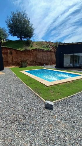 a house with a swimming pool in a yard at Grado8punto8 Glamping Valle de Los Artistas in Lolol