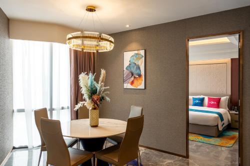 a room with a table and a bed and a bedroom at Imperial Lexis Kuala Lumpur in Kuala Lumpur