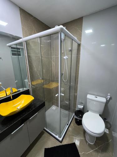 ein Badezimmer mit einem gelben Waschbecken und einem WC in der Unterkunft Flat Alto Padrão 4 in Campina Grande