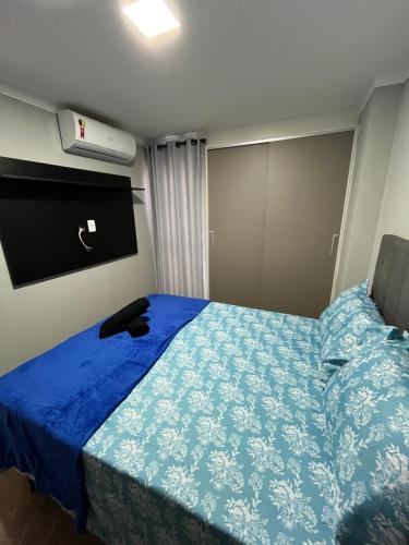 ein Schlafzimmer mit einem Bett mit einer blauen Bettdecke in der Unterkunft Flat Alto Padrão 4 in Campina Grande