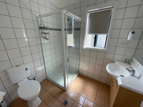 a bathroom with a shower and a toilet and a sink at Pyramid Holiday Park in Tweed Heads