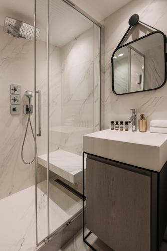 une salle de bain avec un lavabo et une douche dans l'établissement HIGHSTAY - Luxury Serviced Apartments - Louvre-Rivoli, à Paris
