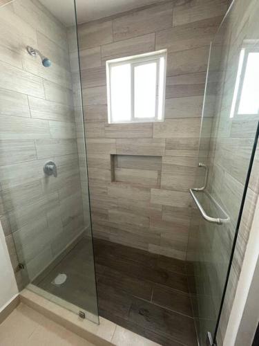a shower with a glass door and a window at Alojamiento en León in Santa Gertrudis