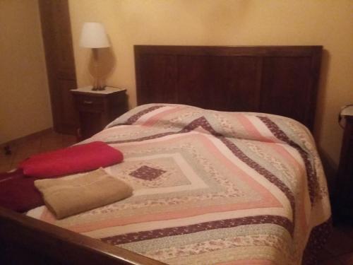 a bed with a blanket and pillows on it at Agriturismo La Buca in Cutigliano