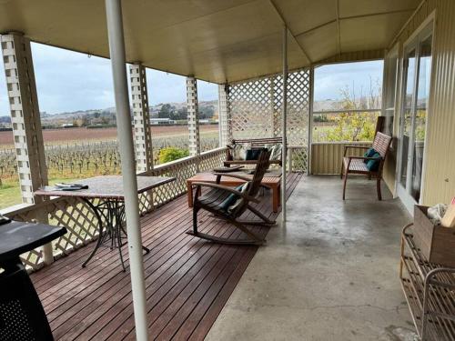 a screened porch with a table and chairs on it at Three Fifty Cottage in Havelock North