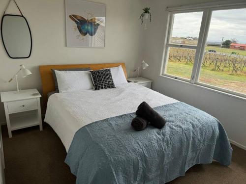 a bedroom with a bed and a large window at Three Fifty Cottage in Havelock North