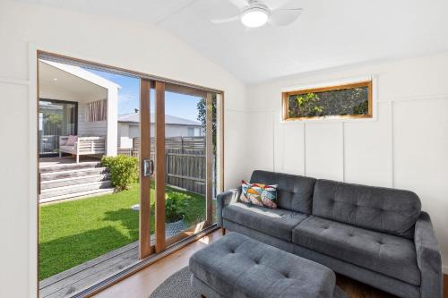 a living room with a couch and a sliding glass door at Luxurious Beach House with Breath-taking Views in Ocean Grove