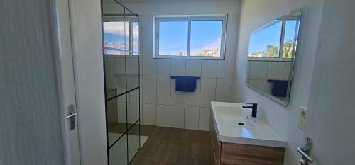 a bathroom with a sink and a mirror at Auberge du MOCAMBO in Noumea