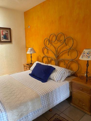a bedroom with a bed with a blue pillow on it at Quinta Ángeles in Cuernavaca