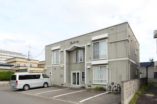 a white van parked in front of a building at プレジール弘前101 in Hirosaki