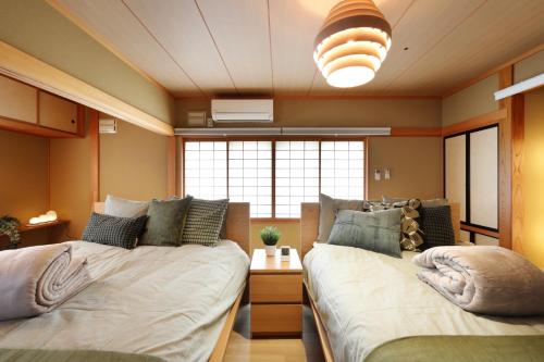 a bedroom with two beds and a large window at プレジール弘前101 in Hirosaki