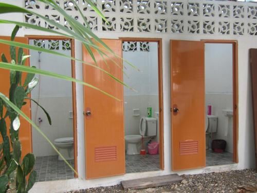 a bathroom with orange doors and a toilet at Sky Beach budget rooms in Catmon