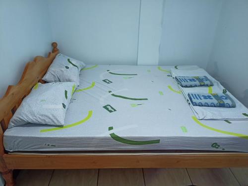 a bed with a comforter and pillows on it at Sky Beach budget rooms in Catmon