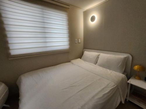 テジョンにあるModern Houseの白いベッドと窓のある寝室