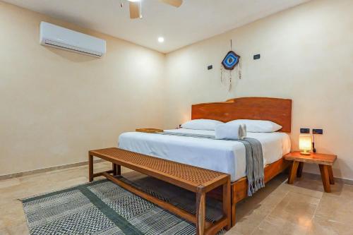 a bedroom with a large bed and a table at Calea Tulum Boutique Hotel in Tulum