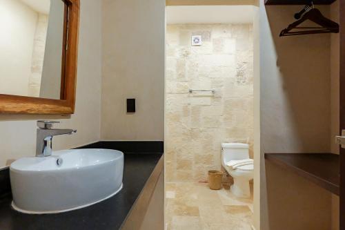a bathroom with a white sink and a toilet at Calea Tulum Boutique Hotel in Tulum