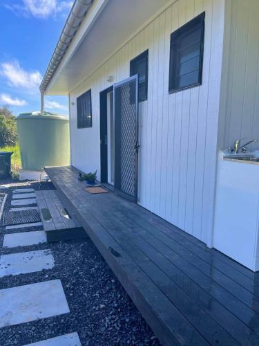 a front porch of a house with a wooden deck at Eryns Retreat in Avarua