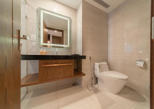 a bathroom with a toilet and a sink and a mirror at Moonlight Bay Panorama Condotel Ocean View in Nha Trang