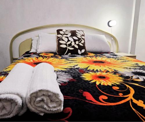 a bedroom with a bed with a floral bedspread at Río Rooms City Center in Quetzaltenango