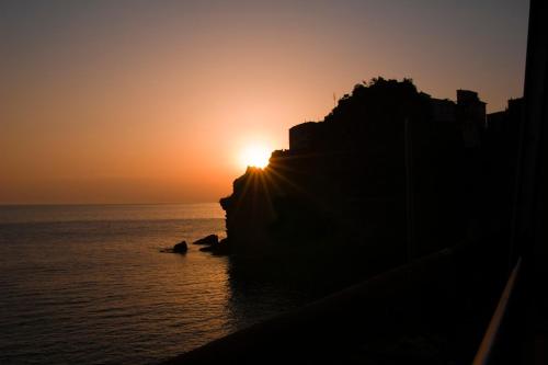 a sunset over the ocean with the sun setting at Zia Letizia Bed And Wine in Monterosso al Mare