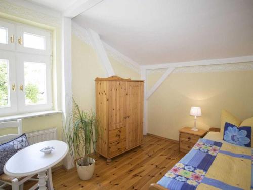 a bedroom with a bed and a table and window at Ostseewelle Comfortable holiday residence in Middelhagen