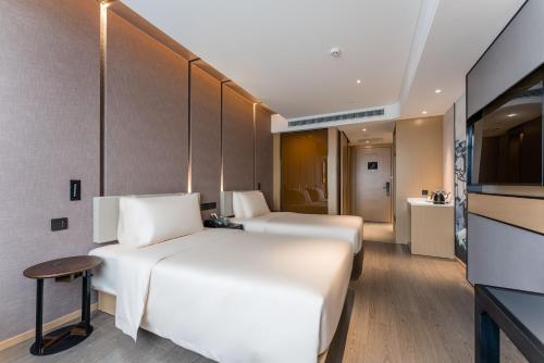 a hotel room with two beds and a kitchen at Atour Hotel Suzhou New District Huaihai Street in Suzhou