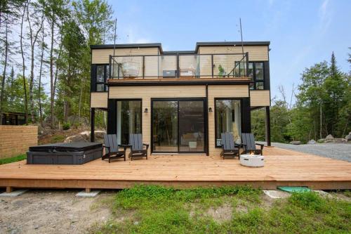 a house with a deck with chairs on it at Ultra Luxurious Modern Chalet Private Jacuzzi in La Conception