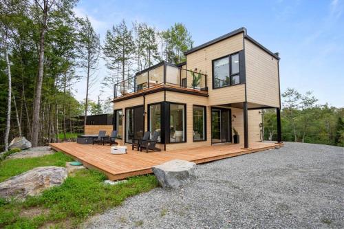 a house with a wooden deck with a lot of windows at Ultra Luxurious Modern Chalet Private Jacuzzi in La Conception