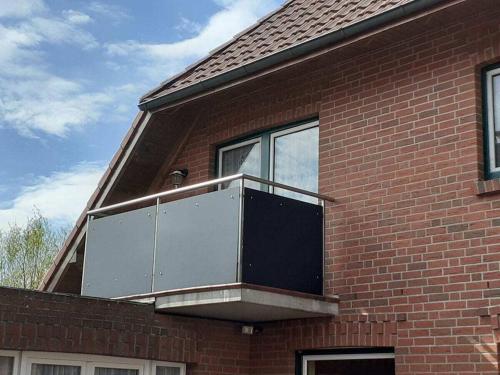 a balcony on the side of a brick building at Starfish" Comfortable holiday residence" in Hooksiel