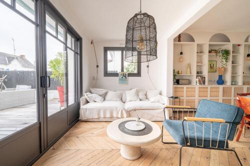 un salon avec un canapé et une table dans l'établissement Belle des Marais, Villa terrasse, plage et bourg à pied, au Pouliguen