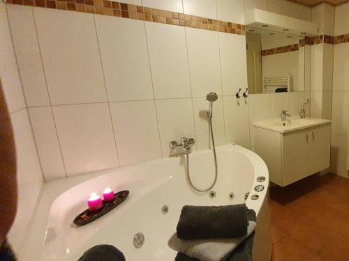 a bathroom with a tub with two candles in it at Klabautermann Comfortable Holiday Residence in Greetsiel