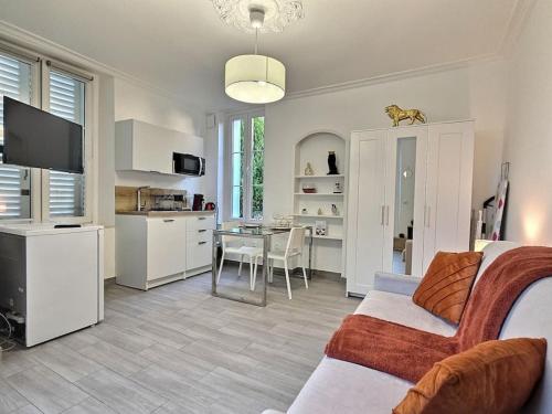 un salon avec un canapé et une cuisine avec une table dans l'établissement Cosy des Rêves II ,Paris, Disney, à Croissy-Beaubourg