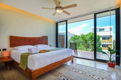 a bedroom with a bed and a large window at Calea Tulum Boutique Hotel in Tulum