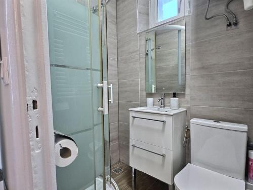 une salle de bain avec toilettes et douche en verre dans l'établissement Cosy des Rêves II ,Paris, Disney, à Croissy-Beaubourg