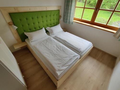 Dormitorio pequeño con cama con cabecero verde en Haringer Comfortable holiday residence, en Schliersee