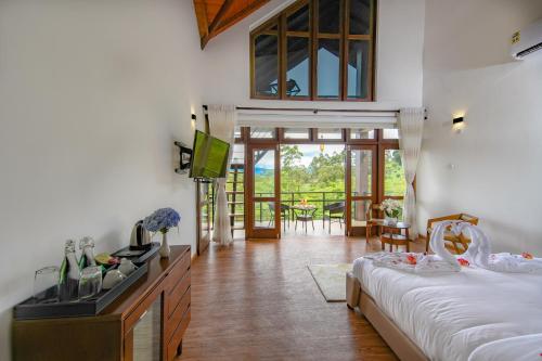 a bedroom with two beds and a balcony with a table at La Casa Lindula Villa Eliya in Nuwara Eliya