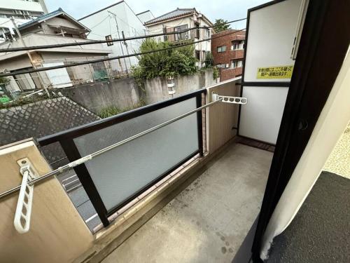 a balcony with a glass door and a view of a city at Town Court Hosoda in Tokyo