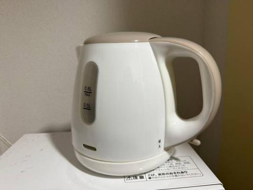 a white kettle sitting on top of a counter at Town Court Hosoda in Tokyo