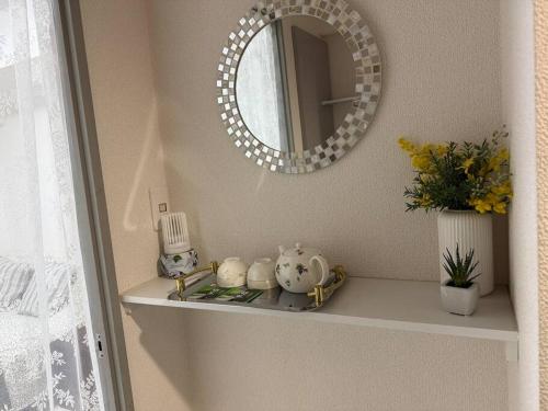 a shelf with a mirror and vases on it at Town Court Hosoda in Tokyo