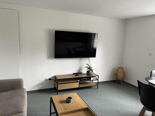 a living room with a flat screen tv on the wall at Mülli's Ferienwohnung Eifel in Kall