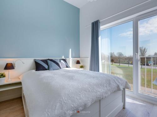 una camera da letto con un letto e una grande finestra di An-der-Ostsee-17 Comfortable holiday residence a Kappeln