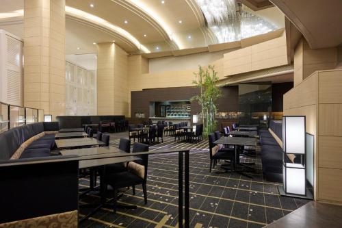 a restaurant with tables and chairs in a building at ANA Crowne Plaza Kanazawa by IHG in Kanazawa