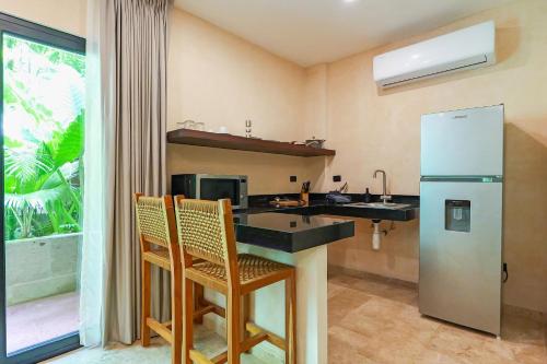 a kitchen with a sink and a refrigerator at Calea Tulum Boutique Hotel in Tulum